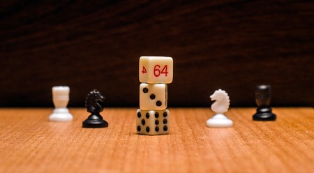 Dice and chess pieces on a wooden background objects for the most popular logical and gambling board...