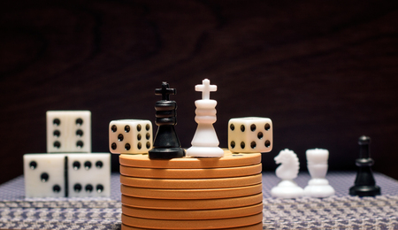 Various objects for the most popular board games on a wooden background chess pieces, dominoes, dice, poker chipsの写真素材