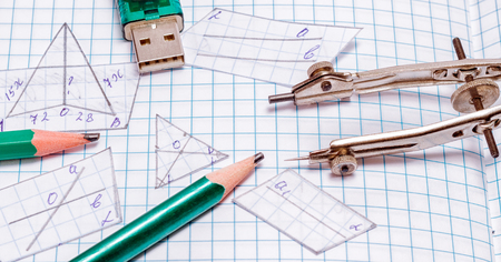Compasses, flash drive, pencils and cut out geometric shapes tools for writing, drawing and acquiring knowledge and new skillsの写真素材