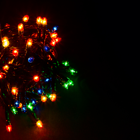 Glow multicolored garlands on a dark background festive lighting red, green, blue