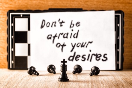 Black chess king servants bowing before him and motivating the inscription in English do not be...