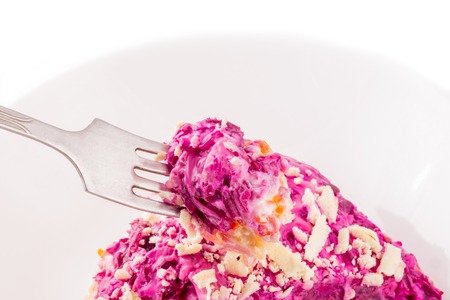 appetizing salad herring under a fur coat on a fork and in a plate is very tasty and festiveの写真素材