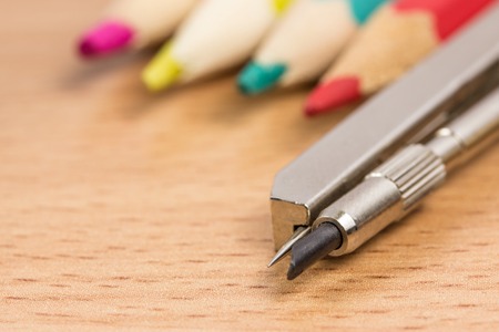 Compasses stand out against the background of colored pencils School supplies for drawingの写真素材