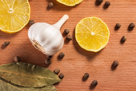 garlic slices of lemon black pepper and bay leaves closeup looks bright and appetizingの写真素材