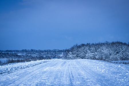 bright winter road shines in the evening under a dark blue sky is very beautifulの写真素材