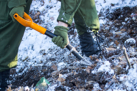 guy in military uniforms digs the ground in winter in the cold seasonの写真素材
