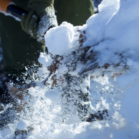 beautifully shovel throws bright white snow snowflakes and lumps fly in different directionsの写真素材
