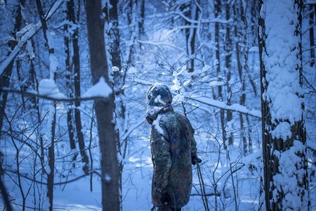 traveler in military uniform in a mystical winter forest at night he alone in the bright light of the moon his clothes covered the white snow with spectacular and beautifulの写真素材