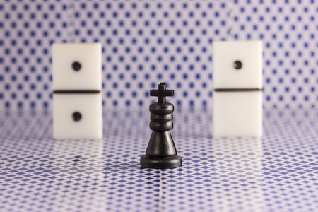 black chess king and dice for dominoes on a blurred background of the back side of playing cards concept of popular board gamesの写真素材