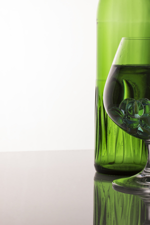 interesting abstraction patterns in a glass with liquid and decorative balls on a gray backgroundの写真素材