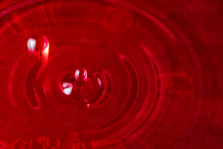 bright bubbles of red wine in motion over a closeup surfaceの写真素材