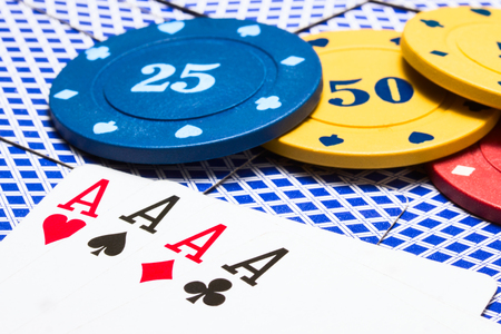 combination of four aces and bright multi colored poker chips concept of gambling