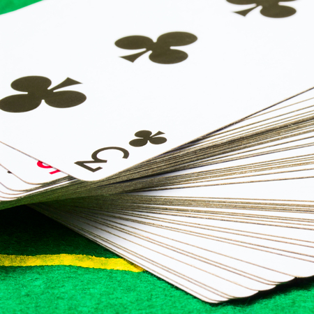 deck of cards with triple clubs on top closeup concept of board games and casino