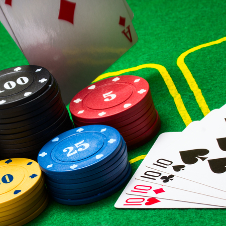 multicolored poker chips behind which falls a diamond ace against a background of bright green...