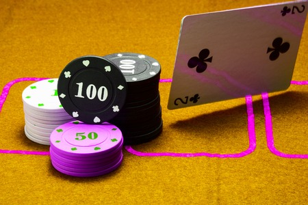 columns of poker chips falling on a table playing cards and a bright box concept of gambling and casinoの写真素材