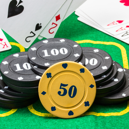 poker chips against the background of falling and lying on the green canvas playing cards concept of...