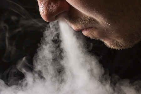 cloud of cigarette smoke man exhales nose of smoking concept and bad habitsの写真素材