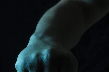 clenched fist on a dark background the concept of struggle and aggressionの写真素材