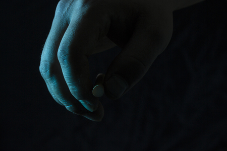 hand holds a cigarette filter on a dark background concept of smoking and addictionの写真素材