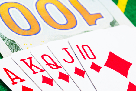 diamond royal flush against a hundred dollar bill closeup concept of casino and gamblingの写真素材