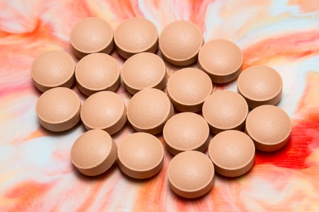 round brown tablets on a beautiful multicolored background concept of medicine and health