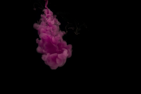 cloud of sprayed violet paint on a dark background art conceptの写真素材