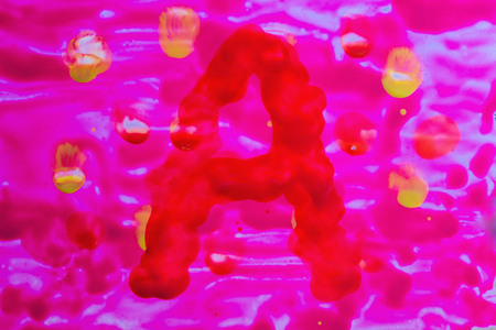 English letter a painted in watercolor on a pink background with patterns denoting falling leaves concept of autumnの写真素材