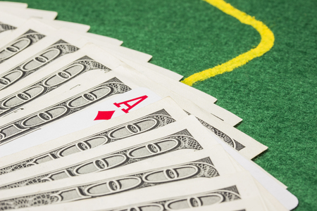 ace of diamonds stands out among the dollar bills concept of luck and poker