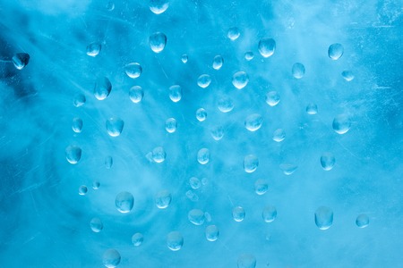 shiny blue water droplets on a bright ice surface winter concept fantastic abstractionの写真素材