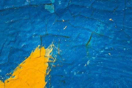 bright metal texture covered with different paint yellow and blue exciting patterns on a grunge surface background for designの写真素材