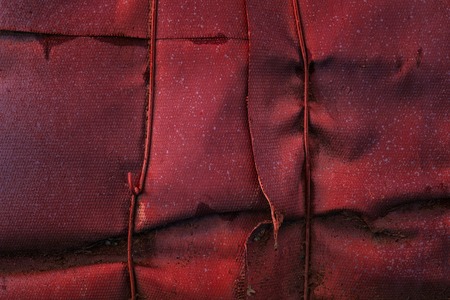 red and mysterious fiberglass texture covering a metal pipe dirty and not smooth surface grunge background for designの写真素材