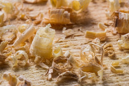 thin and multi-colored wooden shavings lie on the workplace close up woodwork concept
