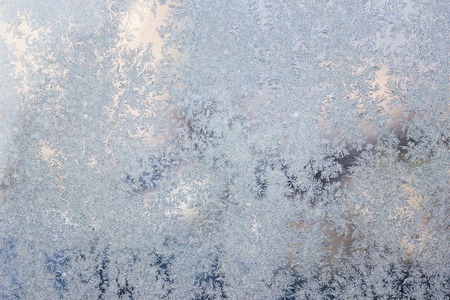 shiny silvery ice patterns covering frozen winter window background for designの写真素材