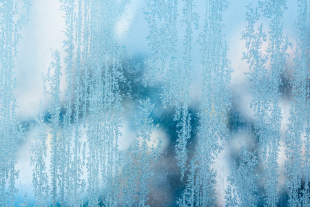 vertical thin ice patterns on a frozen winter glass close-up bright day nature concept background for designの写真素材