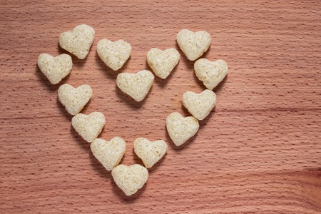 cornflakes heart on wooden board close up food concept