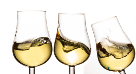 three glasses with white wine bright and splashing objects for design alcohol conceptの写真素材