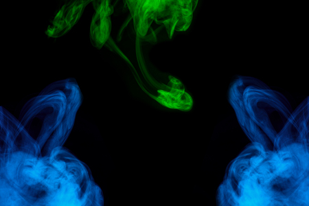 mystical blue and green cloud of cigarette vapor various exciting patterns close-up on a dark background abstraction for design smoking conceptionの写真素材