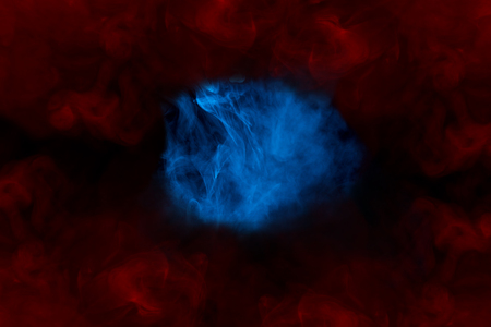 fantastic blue cloud of cigarette vapor looks like an anomaly in a red bewitching frame abstraction...