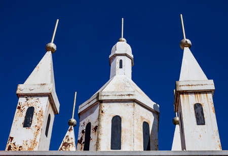 three metal towers with traces of rust against a blue sky