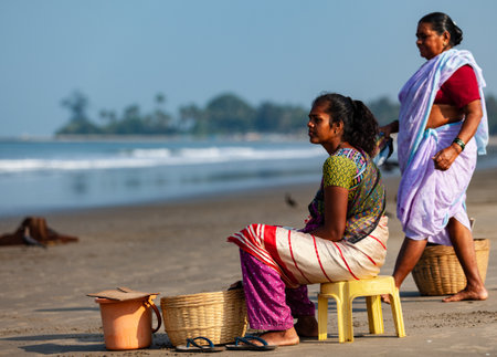 Morjim, North GOA, India - April 01 2016: Indian women on the shore gaze at the ocean. High quality photoのeditorial素材