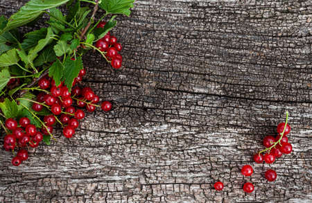 red currant lying on a natural wooden surface. High quality photo