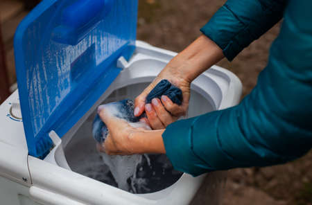 spinning the laundry by hand when washing in the washing machine. High quality photo