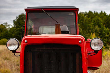 the front of an old tractor standing in a field. High quality photoの写真素材