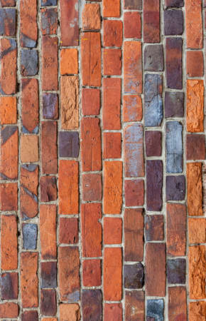 background or texture in the form of a vertical red brick wall. High quality photoの写真素材
