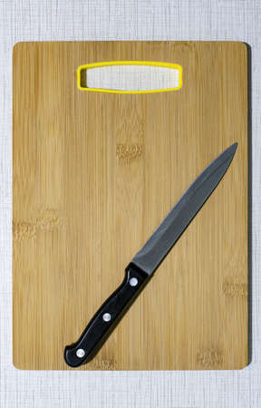 a sharp knife lying on a wooden cutting board. High quality photoの写真素材