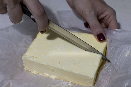 a large piece of butter cut with a knifeの写真素材
