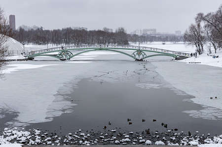 Moscow, Russia - December 07, 2021: iron humpback bridge over a frozen pond. High quality photoのeditorial素材