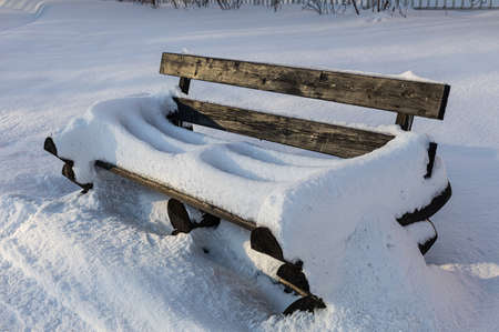empty snow-covered bench in the winter square. High quality photo