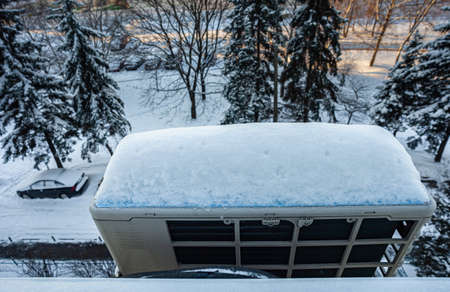 the outdoor unit of the home air conditioner is covered with a layer of snow. High quality photoの写真素材