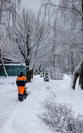 Moscow, Russia - December 14, 2021: man cleans snow in the park. High quality photoのeditorial素材